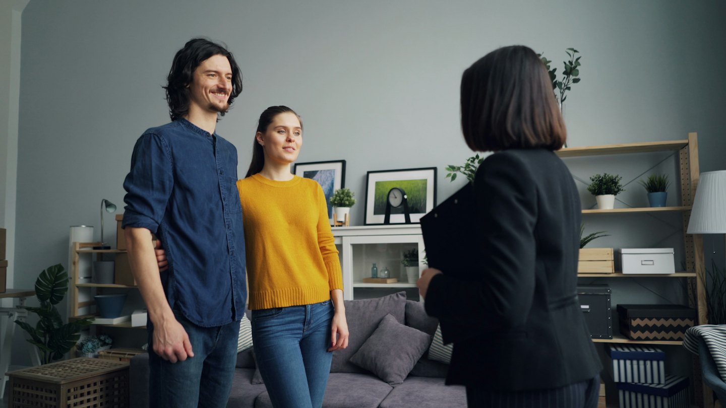 Real estate agent shows unfurnished home to couple.